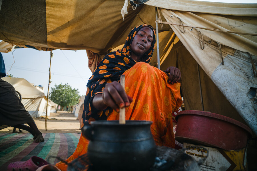 Awadiya makes a traditional sorghum porridge with WFP food - which has been a lifeline for her and her family. WFP/Abubakar Garelnabei