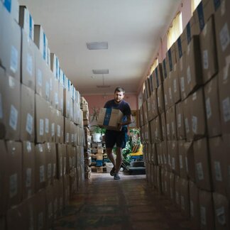 Man carrying a box of relief supplies distributed by WFP