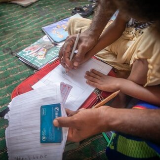 Registering process and signing papers. Photo: WFP/Mohammed Awadh
